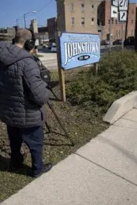 Videographer filming the “Welcome to the City of Johnstown” sign in downtown Johnstown, Pennsylvania.